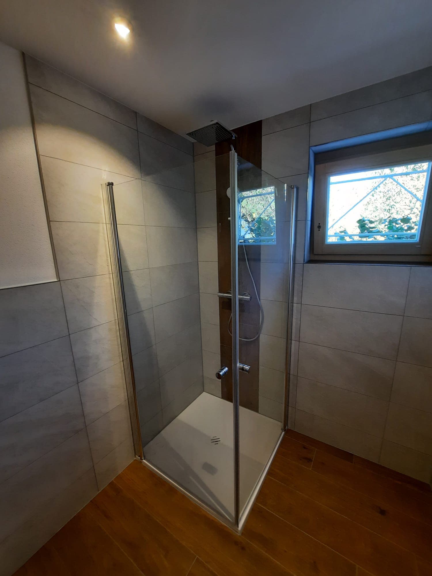 Modernes Badezimmer mit eleganter Duschkabine und hochwertigen Keramikfliesen
