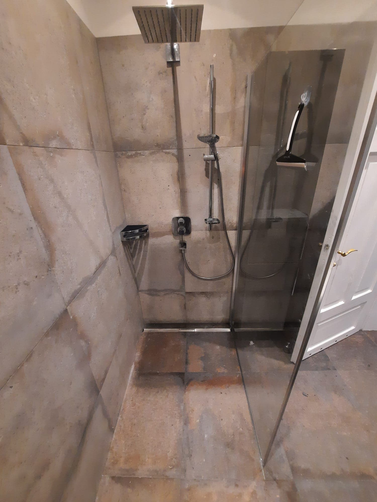 Rustikale Luxus-Dusche mit Natursteinfliesen und moderner Ausstattung