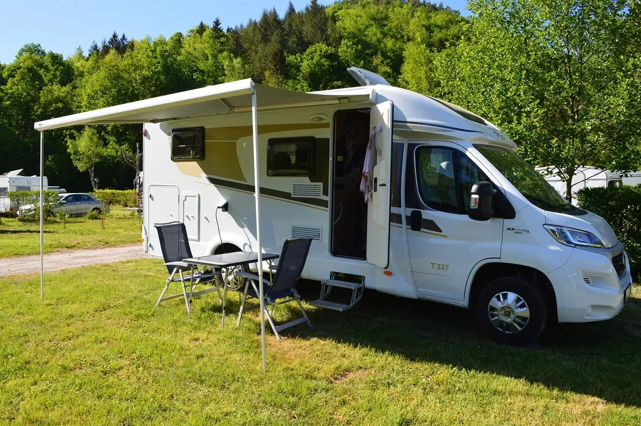 Motorhome and motorbikes parked at a campsite