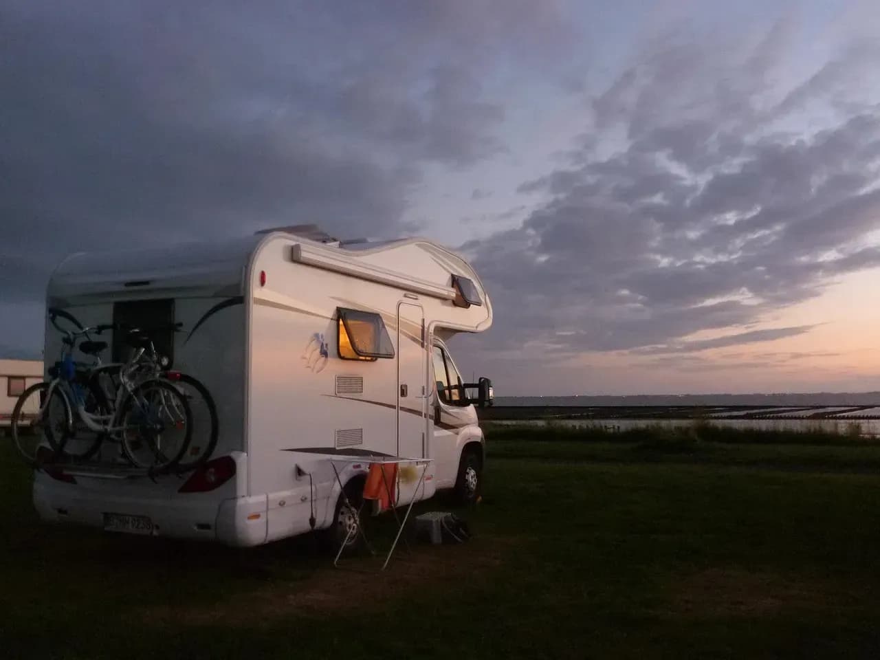 Wohnmobil und Motorradfahrer auf Campingplatz
