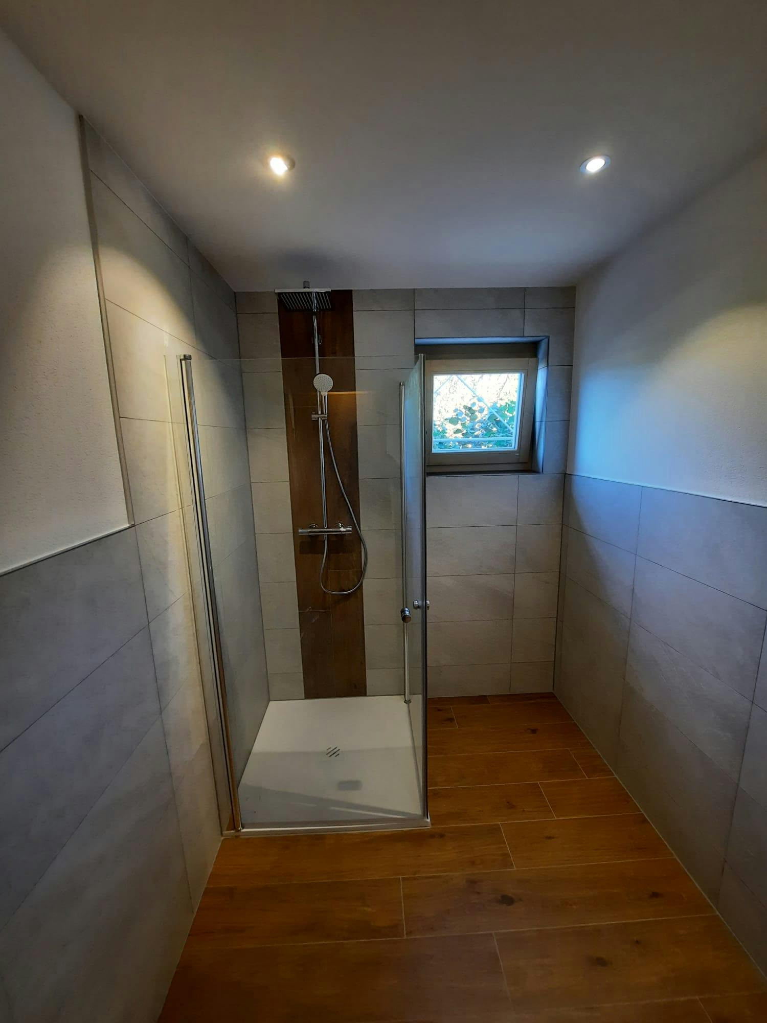 Modernes Badezimmer mit eleganter Duschkabine und hochwertigen Keramikfliesen